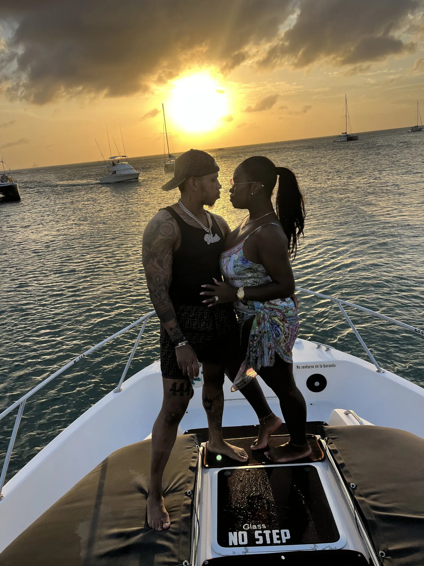 A couple aboard The Midnight Sun Yacht, sunset behind them
